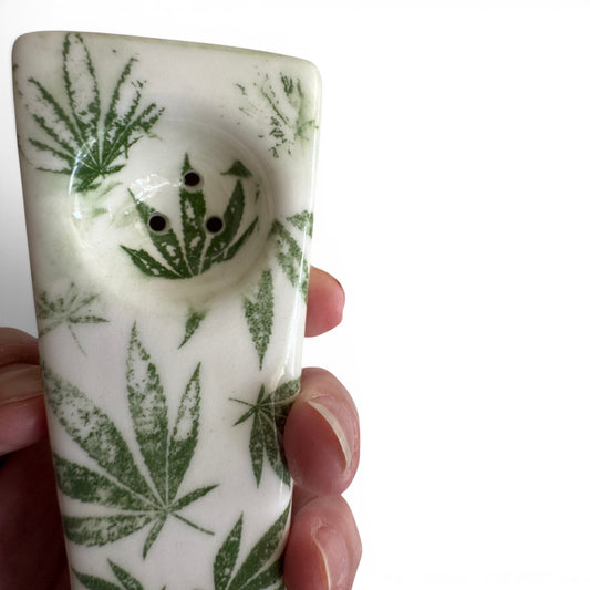 Rock N Art Shop hand-decorated white stoneware pipe with green cannabis leaf design, 5" long