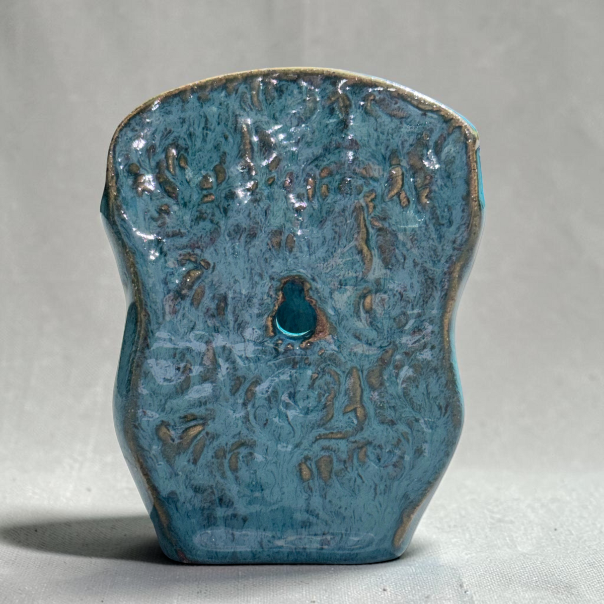 Rock N Art Shop handmade speckled stoneware wall pocket vase in turquoise and blue with a textured backplate.