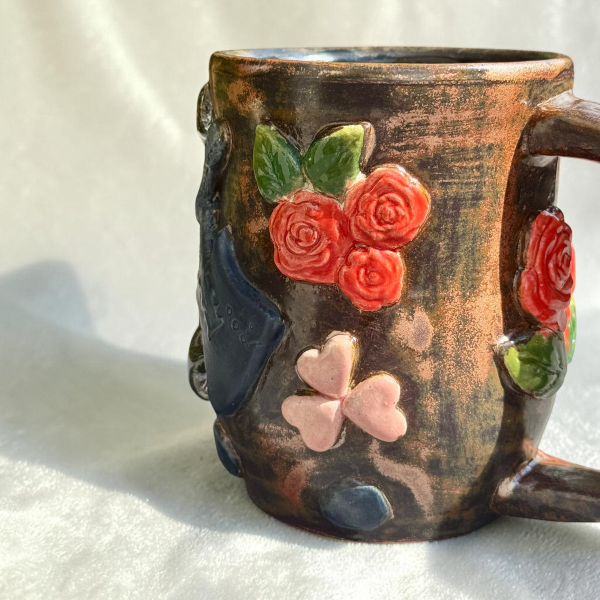 Rock N Art Shop 16 oz handmade stoneware mug with dimensional red roses, pink hearts, and bronze-toned metallic glaze.