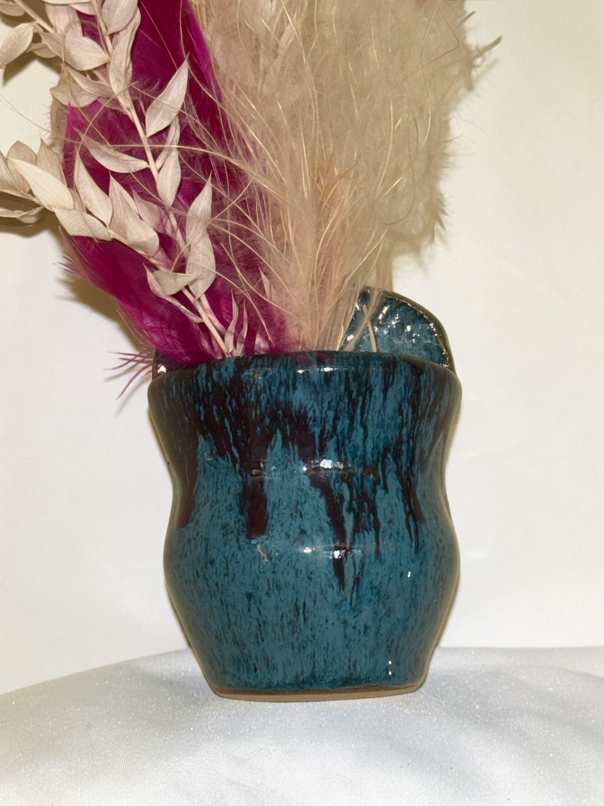 Rock N Art Shop handmade turquoise and blue stoneware wall pocket vase with plum-brown glaze and decorative feathers.