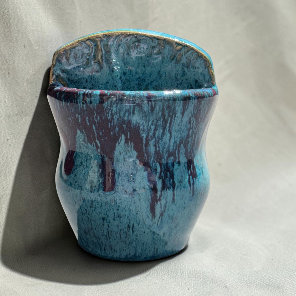 Rock N Art Shop handmade speckled stoneware wall pocket vase in turquoise and blue with plum-brown glaze drips.