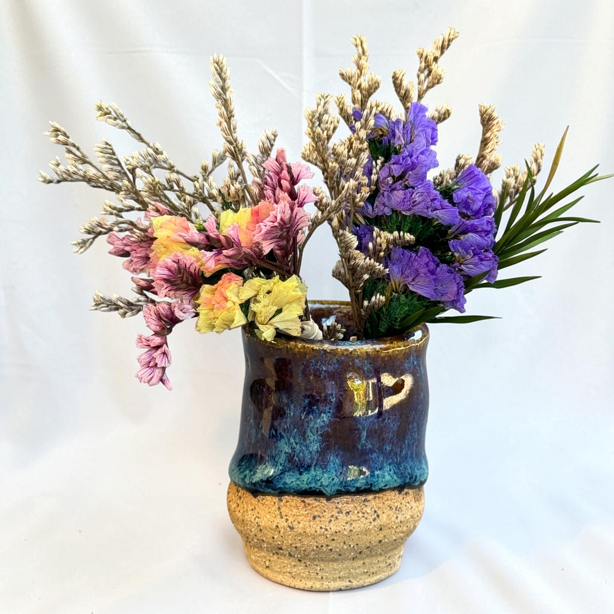 Rock N Art Shop handmade ceramic bud vase with blue, brown, and turquoise glaze and exposed speckled clay base.