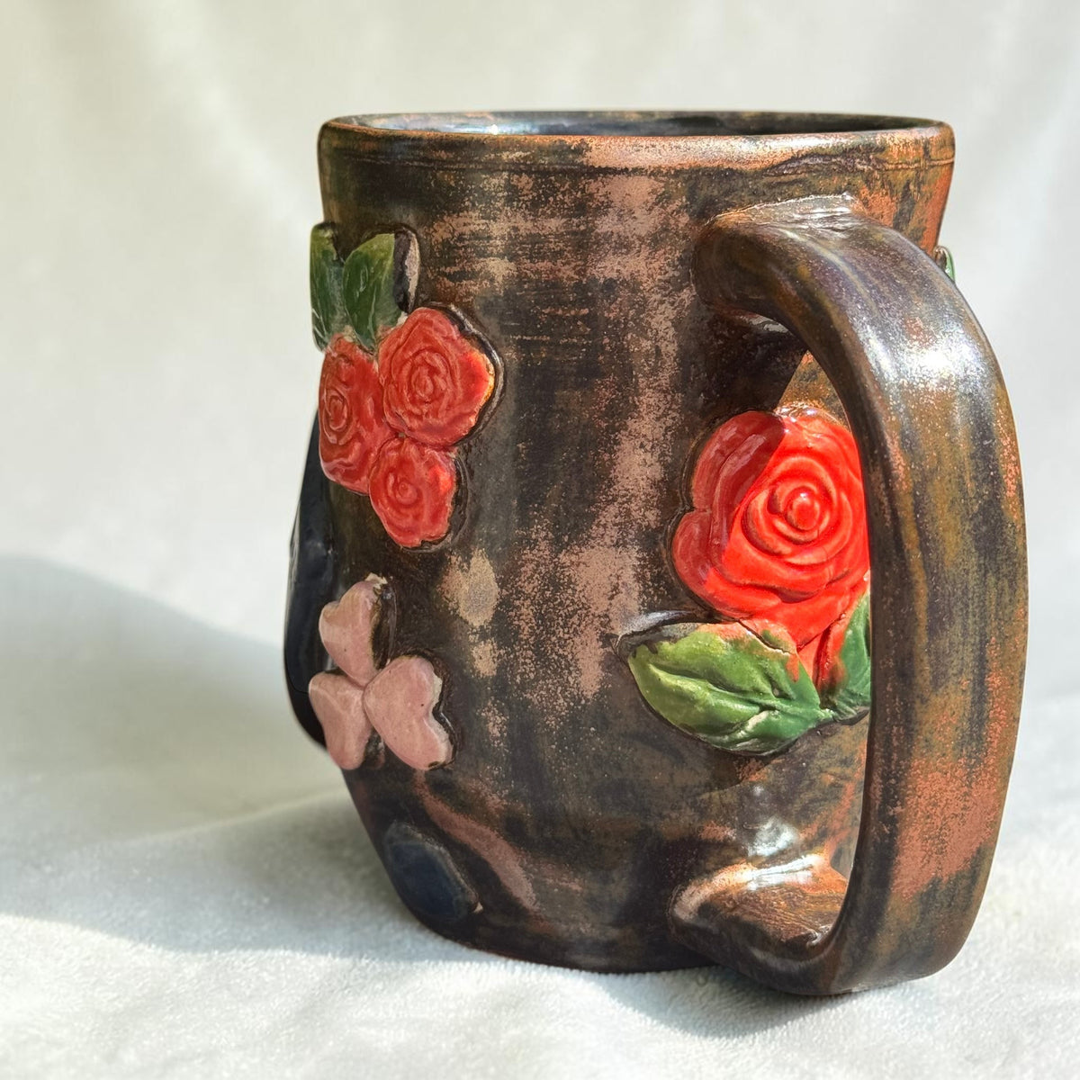 Rock N Art Shop handmade 16 oz stoneware mug with bronze glaze, dimensional red roses, and green leaves.