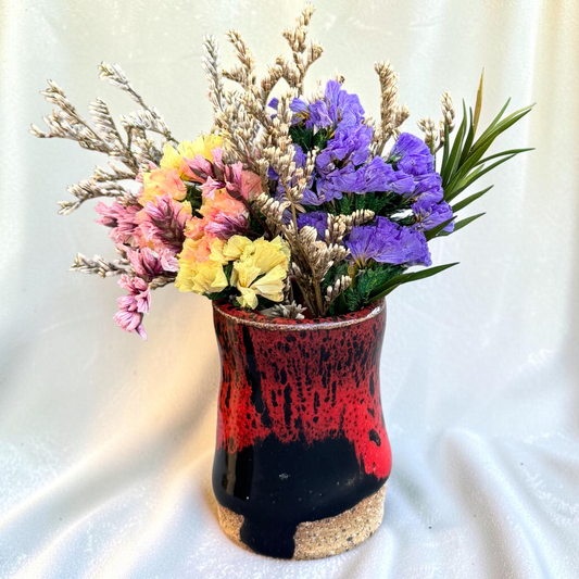 Rock N Art Shop mini ceramic bud vase with red and black glaze and dried flowers on a grey surface