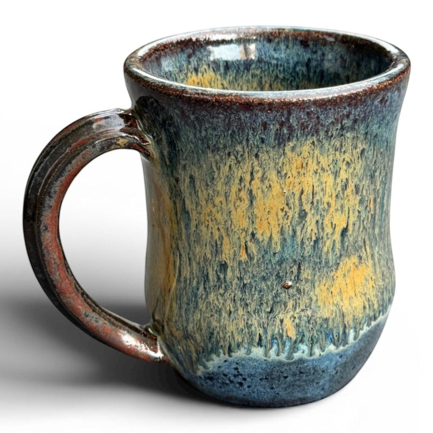 Rock N Art Shop handmade stoneware mug with blue, gold, and green drip glaze. Rustic wheel-thrown pottery, 14 oz capacity.