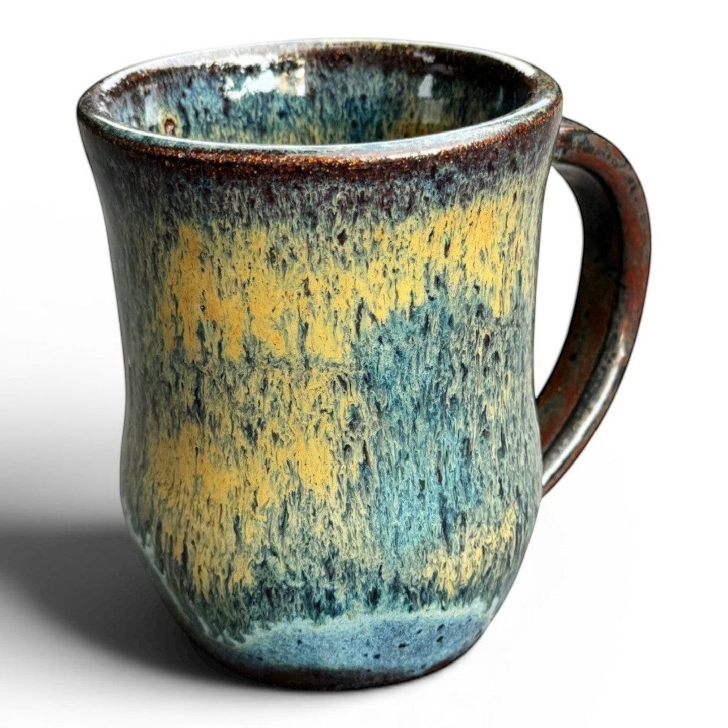Rock N Art Shop handmade stoneware mug with blue, gold, and green drip glaze. Rustic wheel-thrown pottery, 14 oz capacity.