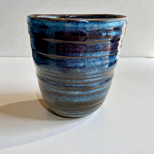 Rock N Art Shop handmade blue stoneware tumbler, 12 oz wheel-thrown pottery with layered blue glaze and horizontal texture.