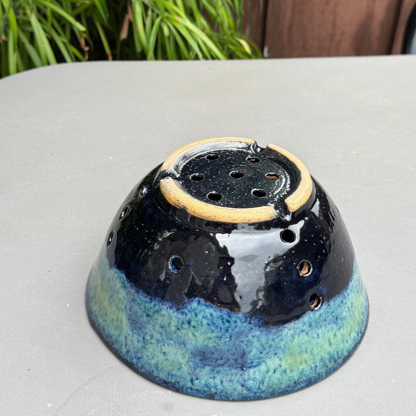 Rock N Art Shop handmade stoneware berry bowl in blue and turquoise glaze showing the underside with drainage holes