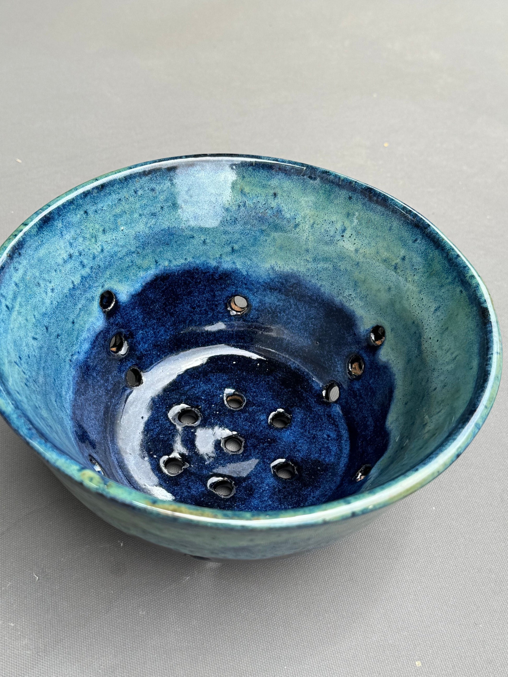 Rock N Art Shop handmade ceramic berry bowl in blue and turquoise stoneware with drainage holes for rinsing fruit