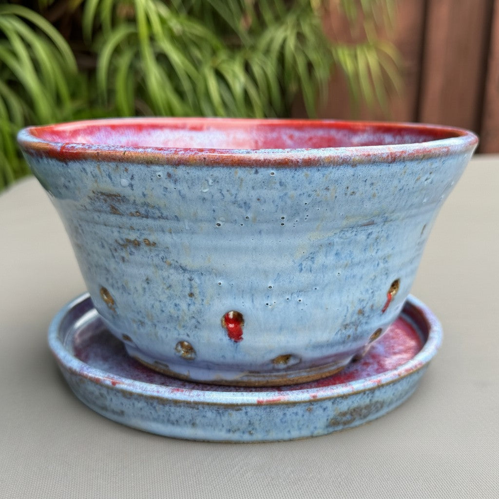 Rock N Art Shop handmade speckled stoneware berry bowl with a blue exterior, ruby red interior, and matching saucer.