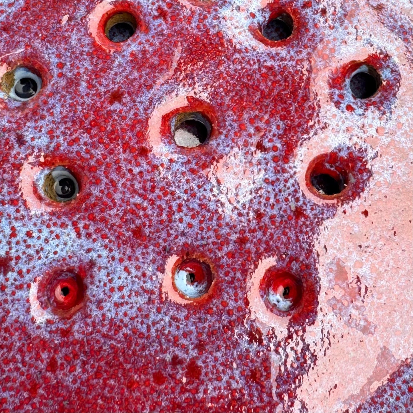 Rock N Art Shop handmade ceramic berry bowl base with drainage holes and vibrant ruby red speckled glaze.