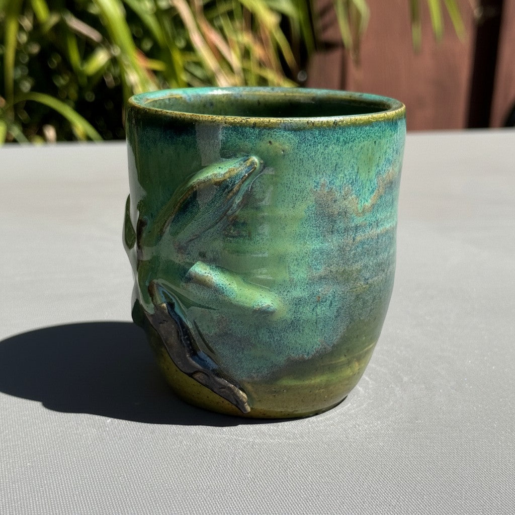 Rock N Art Shop handmade stoneware tumbler with turquoise and green glaze and a sculpted dragonfly detail.