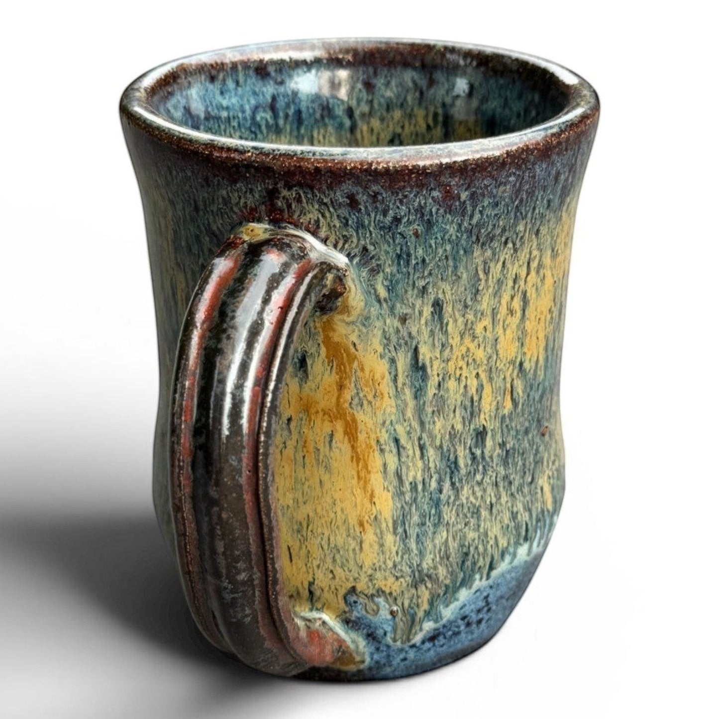Rock N Art Shop handmade stoneware mug with blue, gold, and green drip glaze. Rustic wheel-thrown pottery with a comfortable handle.