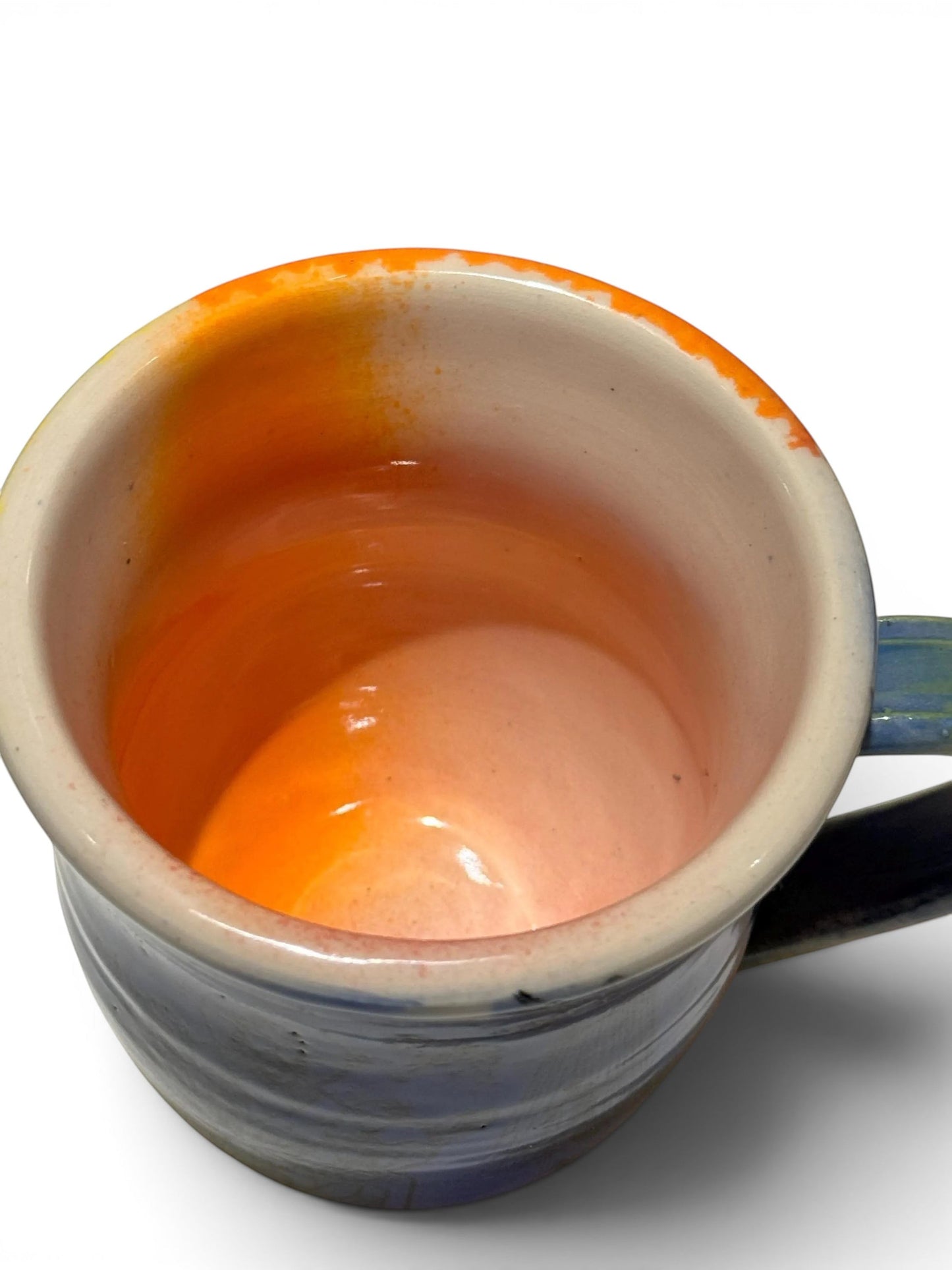 Rock N Art Shop handmade 12 oz ceramic coffee mug with a vibrant orange interior and blue exterior, featuring a unique rock n roll design.