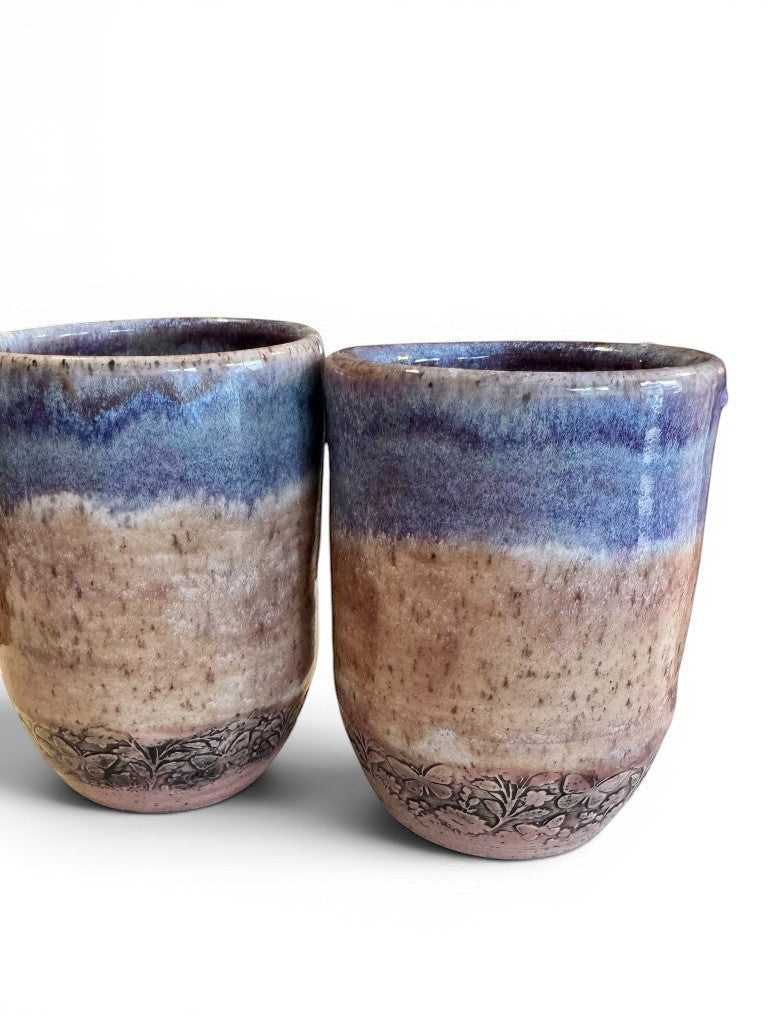 Rock N Art Shop set of two handmade ceramic tumblers, 12 oz, with soft blue & lavender glaze and floral relief detail.