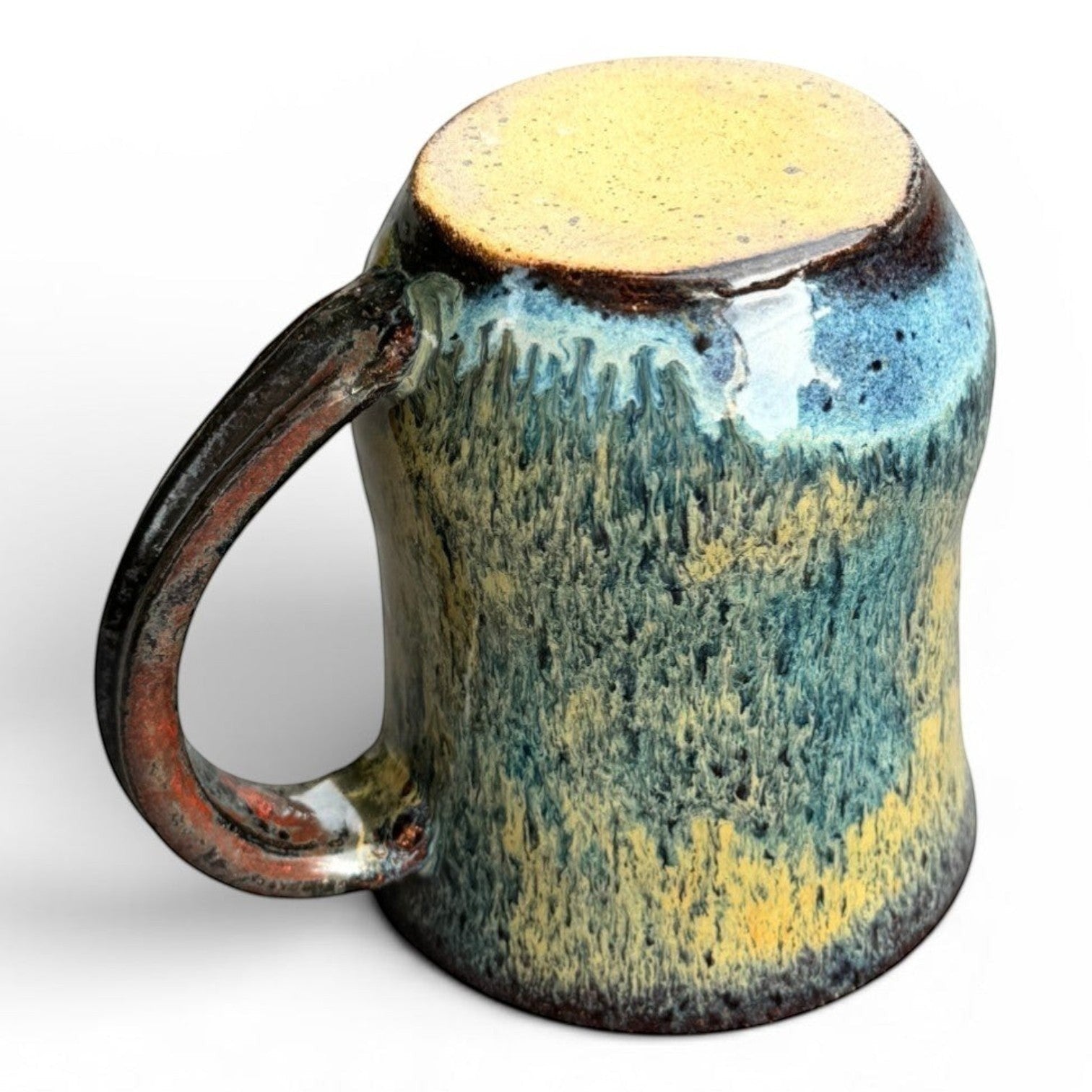 Rock N Art Shop handmade stoneware mug with blue, gold, and green drip glaze. Rustic wheel-thrown pottery with comfortable handle.