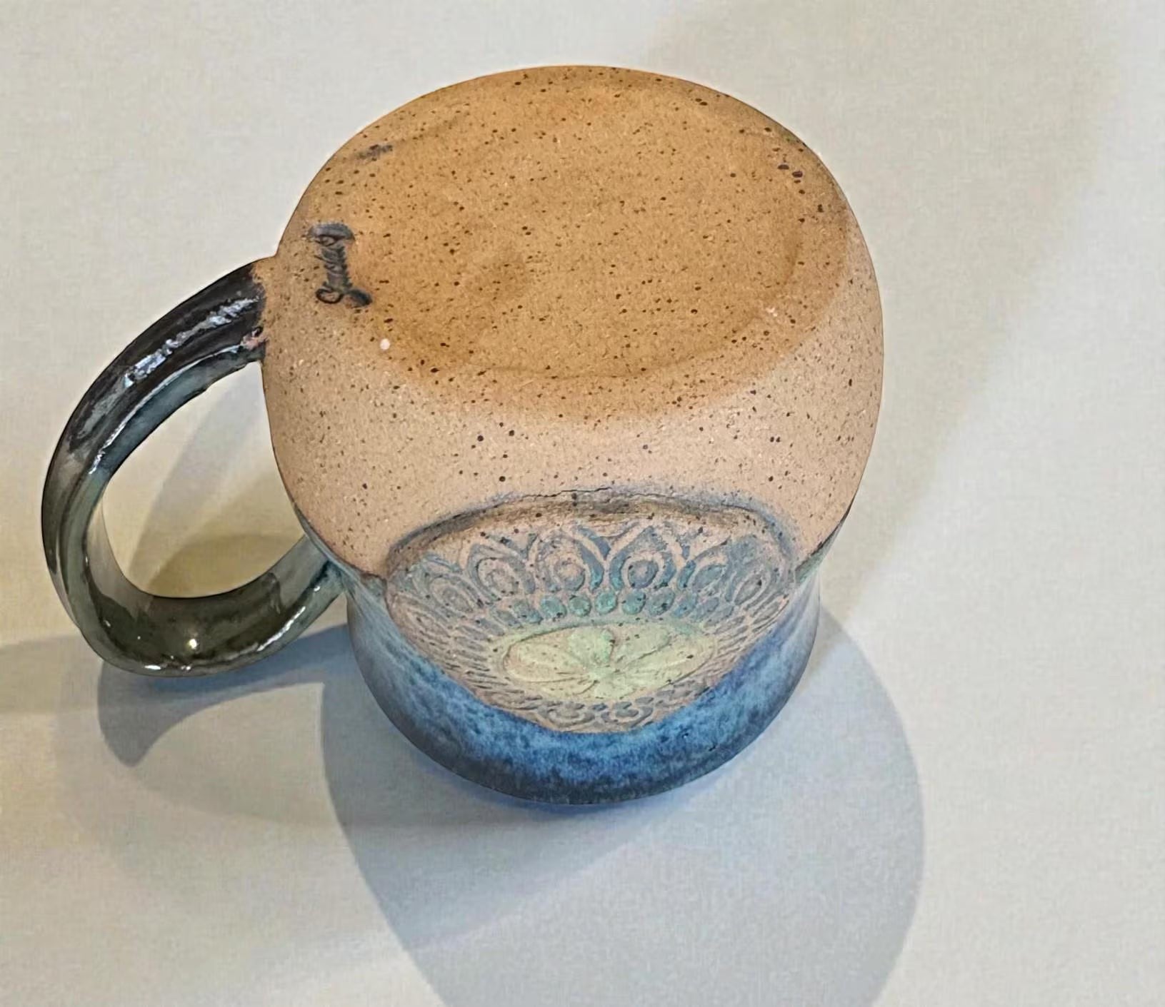 Rock N Art Shop handmade stoneware mug with ocean blue and seafoam green glaze, featuring a mandala relief appliqué.