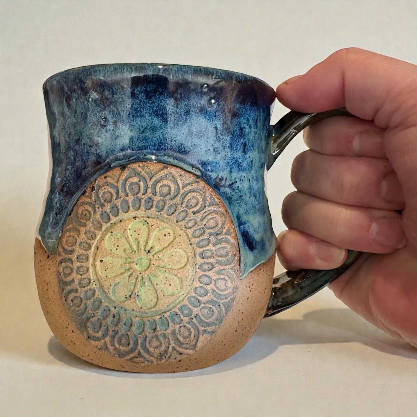 Rock N Art Shop handmade stoneware mug with ocean blue and seafoam green glaze, featuring a mandala relief appliqué.