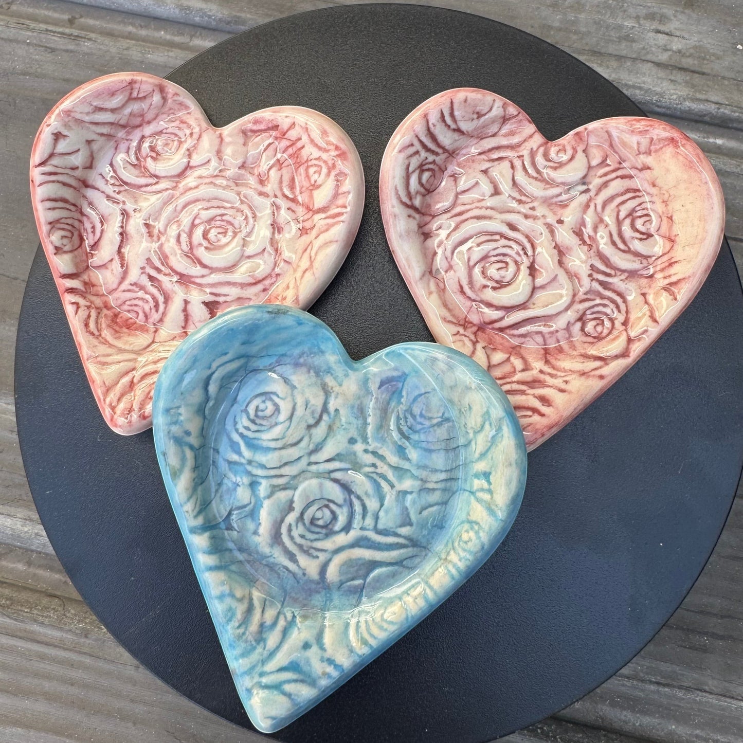 Rock N Art Shop heart-shaped stoneware ring dish with rose relief pattern in sky blue and pink watercolor wash.