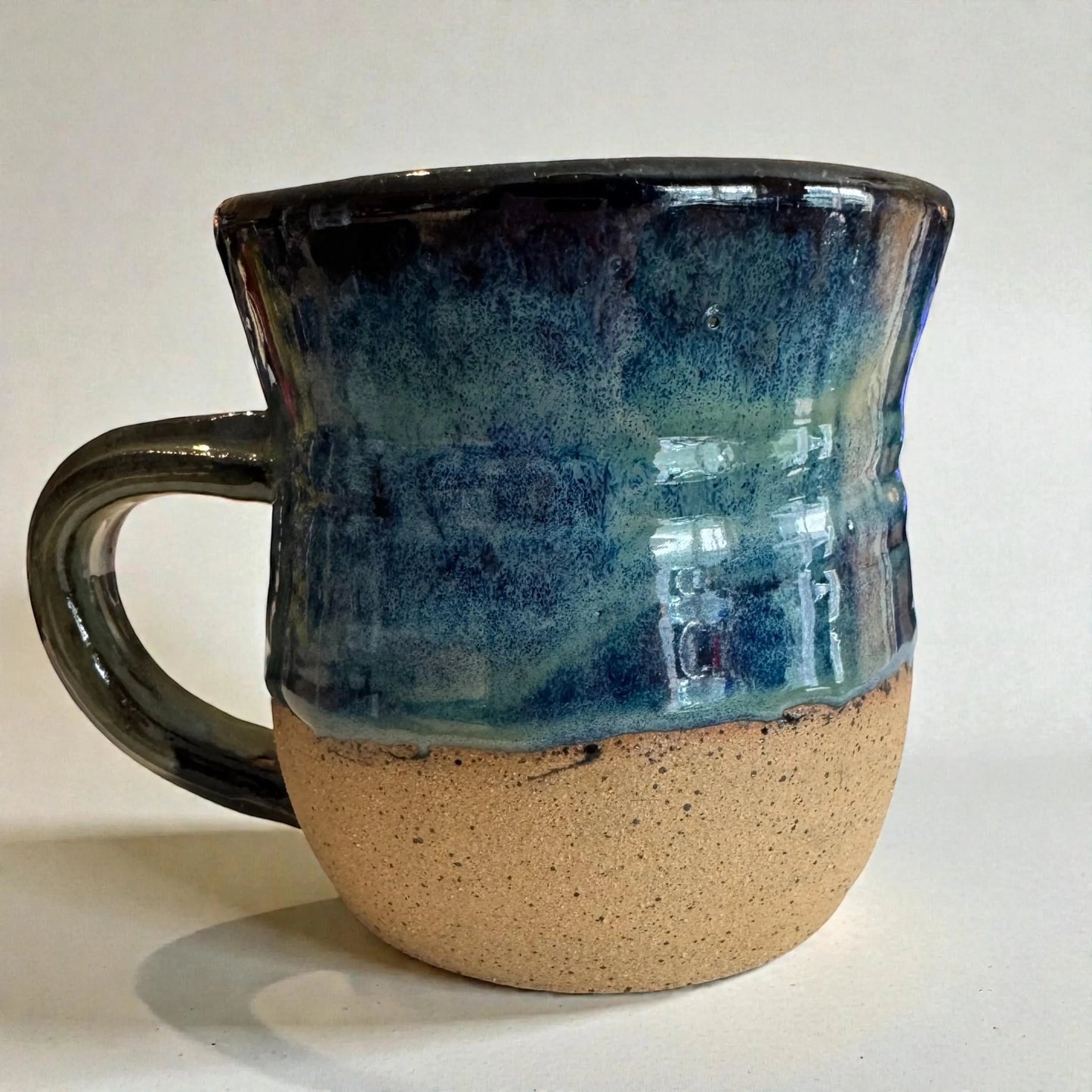 Rock N Art Shop handmade 15 oz stoneware mug with ocean blue and seafoam green glaze, featuring a mandala medallion appliqué.