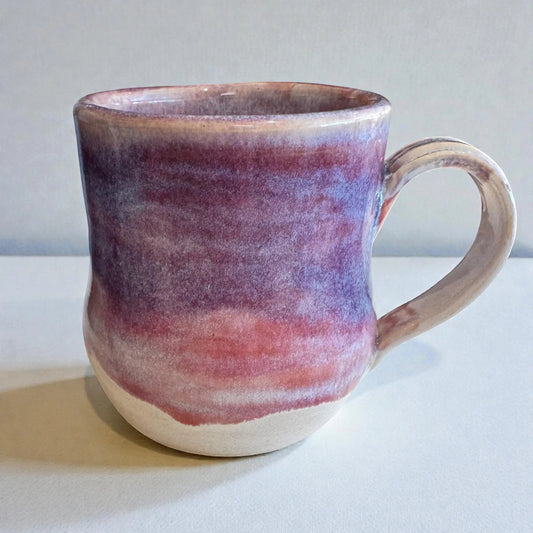 Rock N Art Shop 12 oz handmade stoneware mug with layered plum, mauve, and neutral glaze. Features a comfortable handle and satin-to-gloss finish.