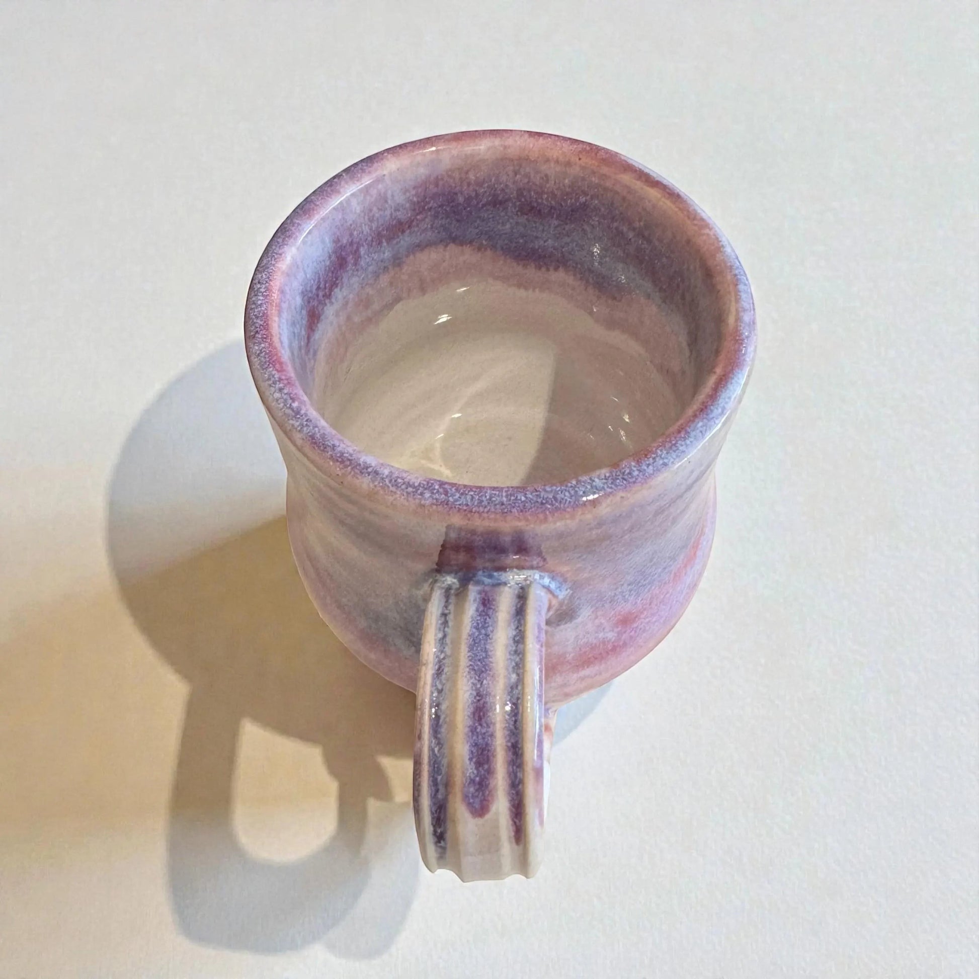 Rock N Art Shop handmade 12 oz stoneware mug with plum and mauve glaze. Features a ribbed handle and a satin-to-gloss finish.