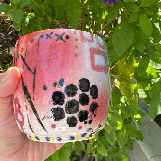 Rock N Art Shop hand-painted stoneware tumbler with pink, blue, yellow, and black pop art design. 12 oz capacity.