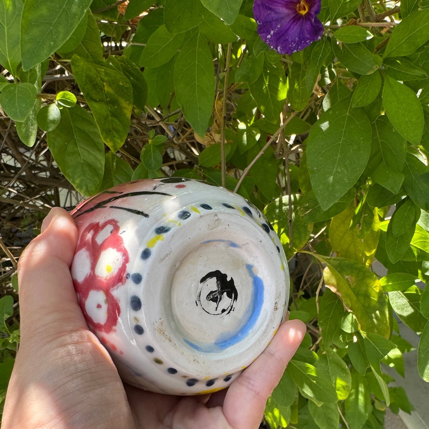 Rock N Art Shop hand-painted stoneware tumbler with pop art design in pink, blue, yellow, and black. 12 oz capacity.