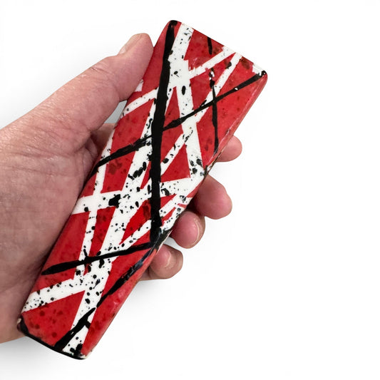 Rock N Art Shop hand-decorated stoneware tobacco pipe with red, black, and white diagonal stripe design and black splatter accents.