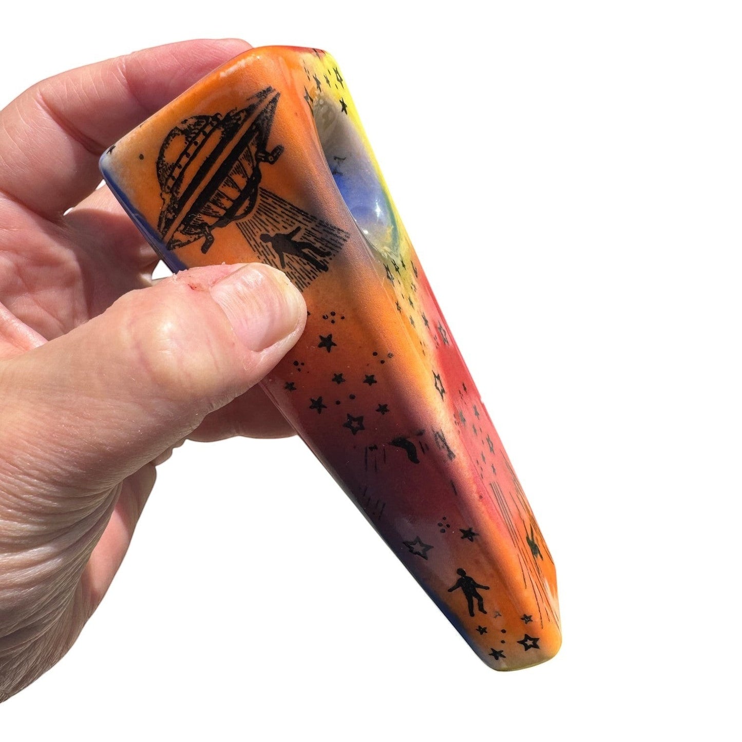 Rock N Art Shop hand-decorated ceramic pipe with UFO and cosmic star design, approx. 5" long, orange, red, yellow, and blue glaze.